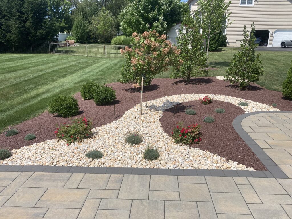 Unique decorative stone swirl bed with paver patio and walkway in Hellertown