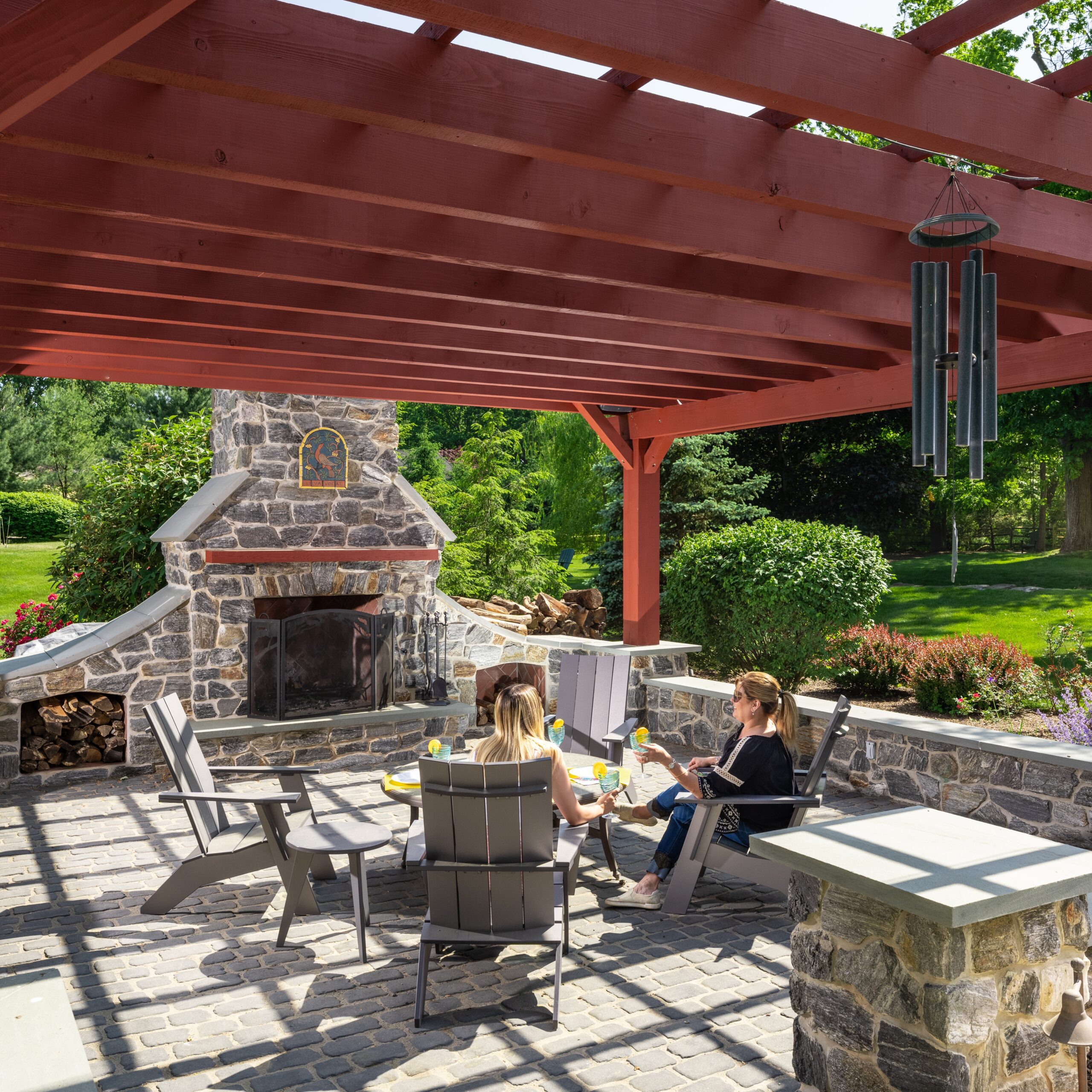 Relaxing beneath a pergola in front of an outdoor fireplace in Center Valley
