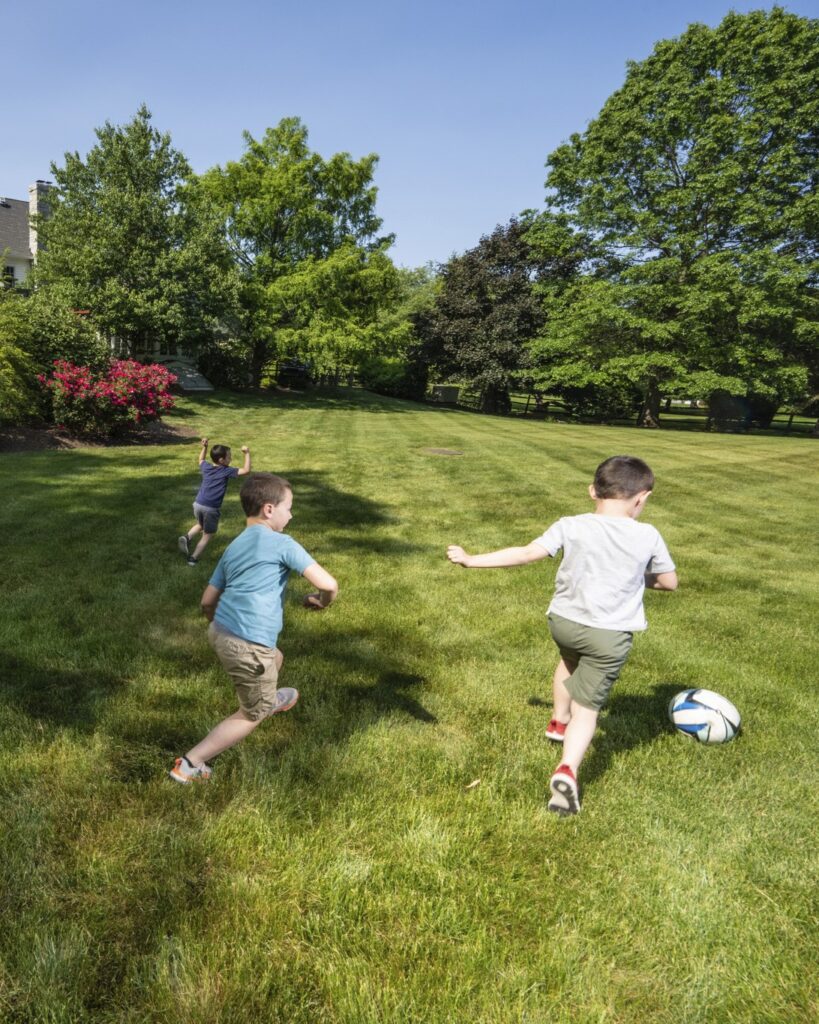 Children playing soccer on a healthy green lawn in Coopersburg