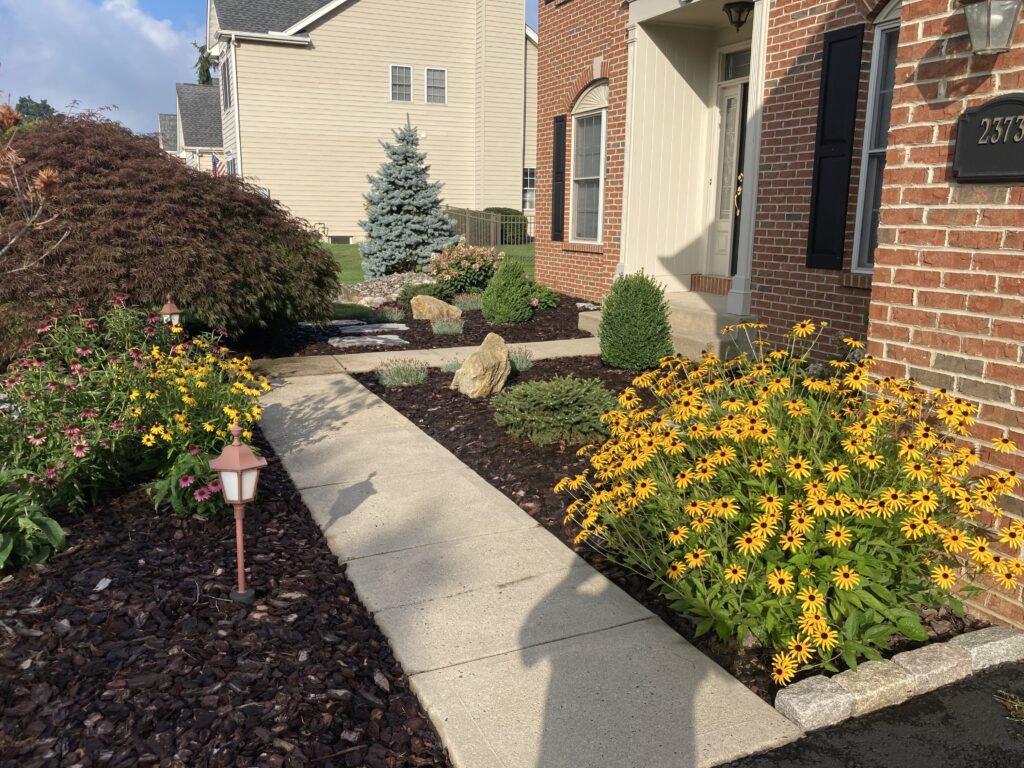 Mulch beds with outdoor lighting and flowers in bloom in Breinigsville