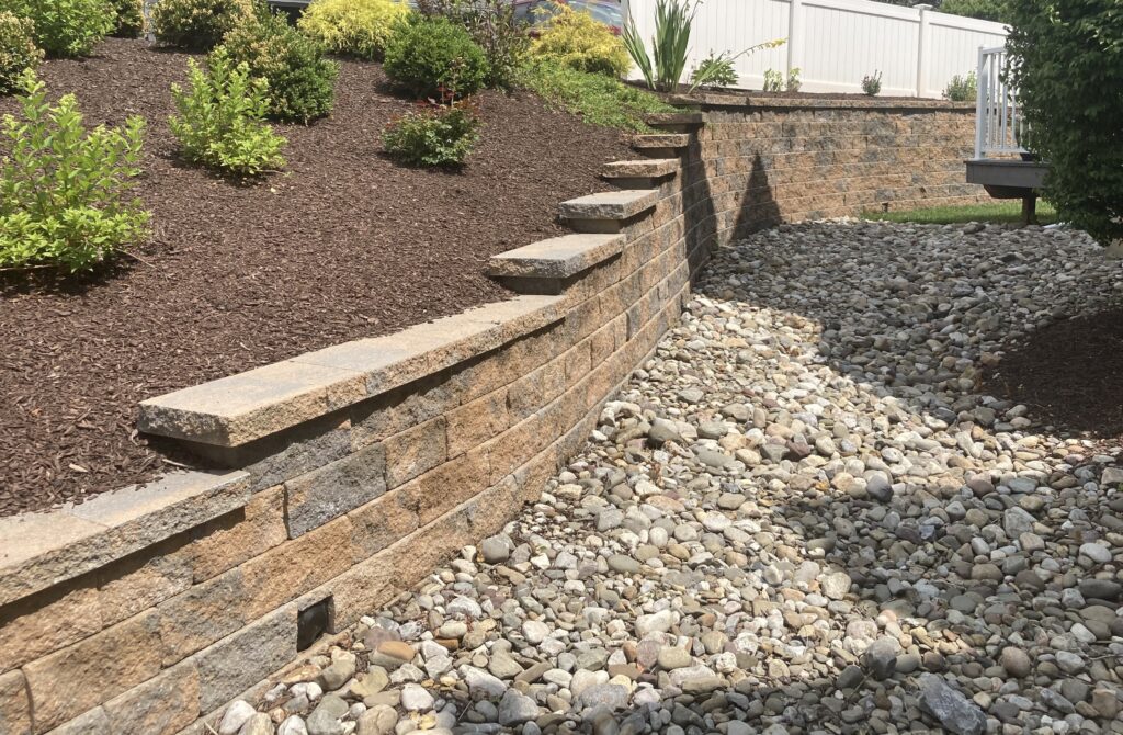Retaining wall with mulch and decorative stone in Center Valley