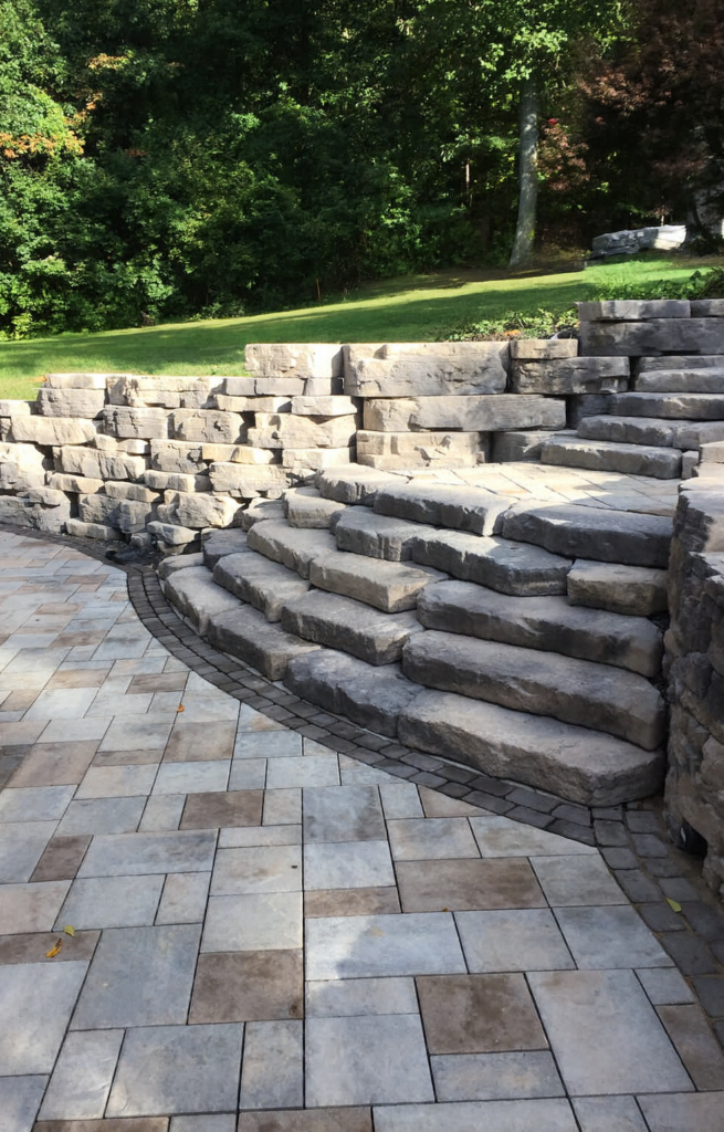 Natural looking paver steps and wall over a paver patio
