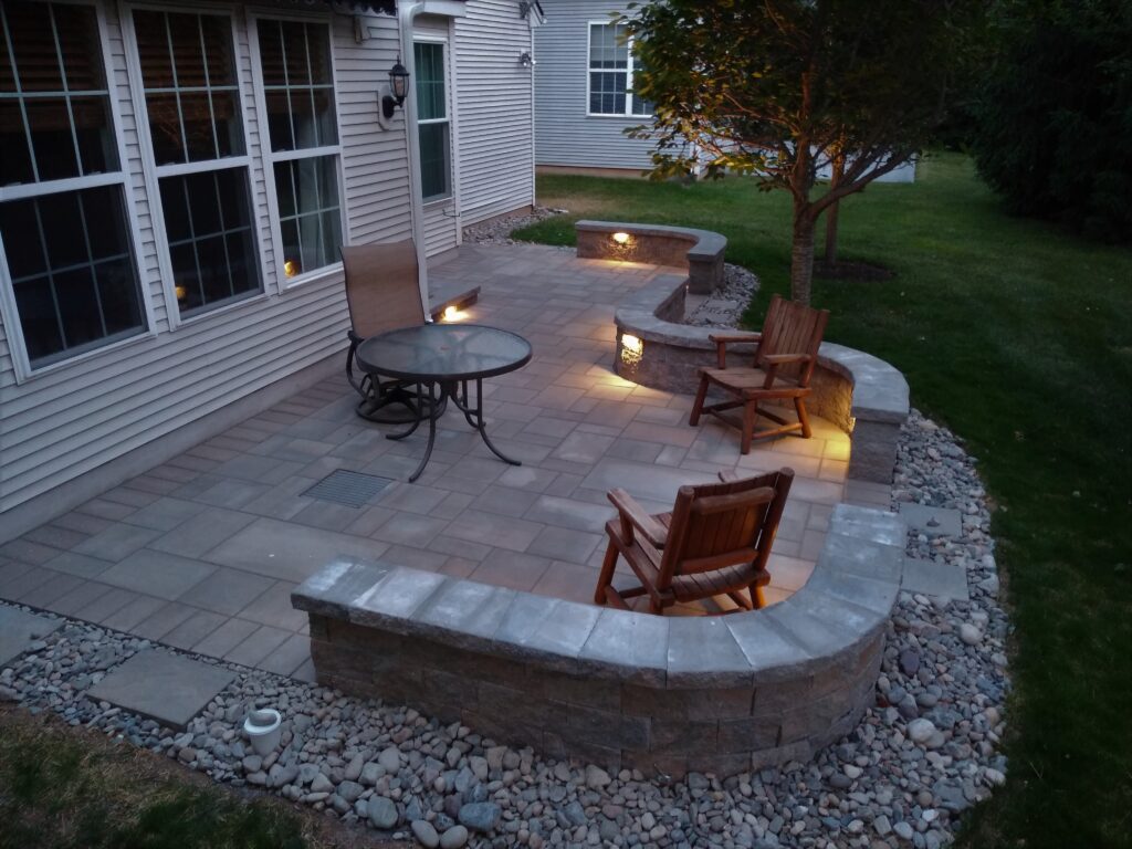 A small patio with outdoor lighting and a sitting wall